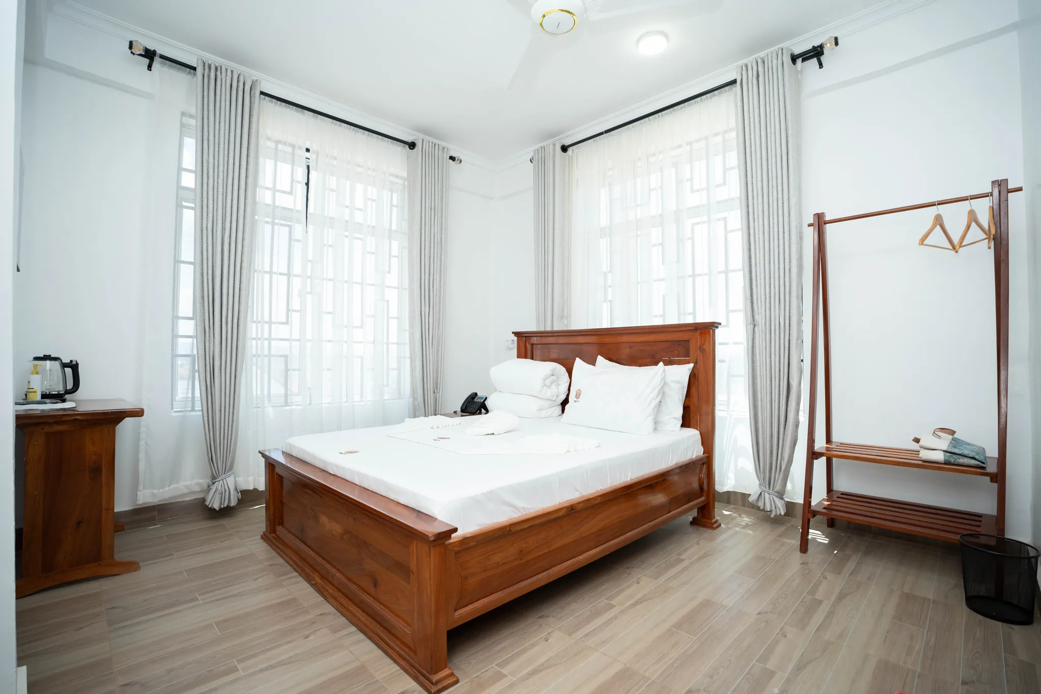 A bright guest room with a wooden bed and seating